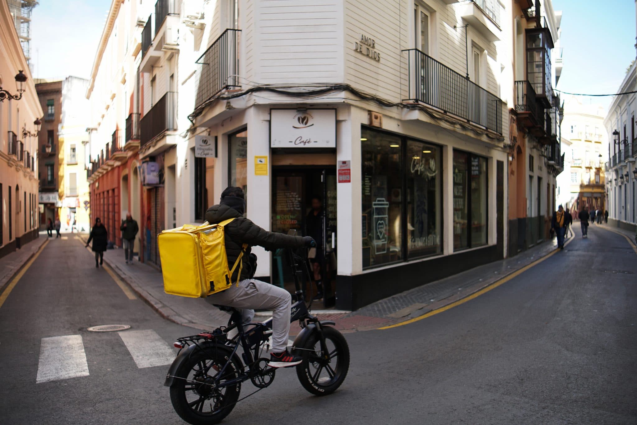 Livreur à vélo électrique avec sac isotherme jaune, en pleine livraison rapide à Agadir