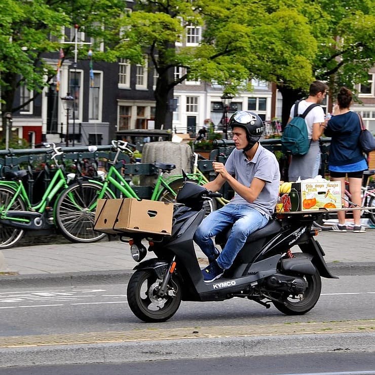 Livreur Tiziwiz SARL à scooter en pleine livraison dans les rues d'Agadir